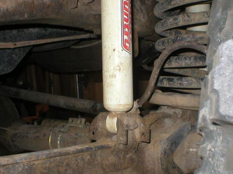 1978 Ford Bronco - Close-up view of a vehicle's rear suspension components, including a shock absorber and coil spring.