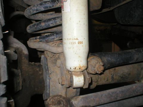 1978 Ford Bronco - Close-up view of a vehicle's suspension system, focusing on a shock absorber and related components.
