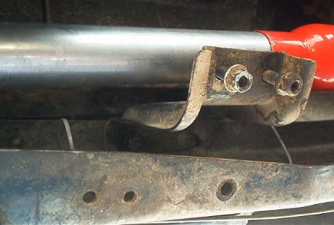 1986 Ford Bronco - Underside view of a vehicle's exhaust system, showing a metal pipe and its mounting hardware.
