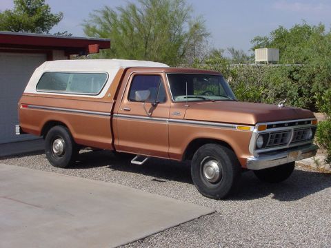 1977 Ford F-250 - This pickup truck features a distinctive grille and a camper shell, suggesting it is from the mid-1970s.