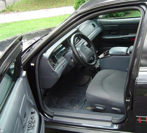 1999 Ford Crown Victoria - The interior of a 1999 Ford Crown Victoria is visible with the driver's side door open.