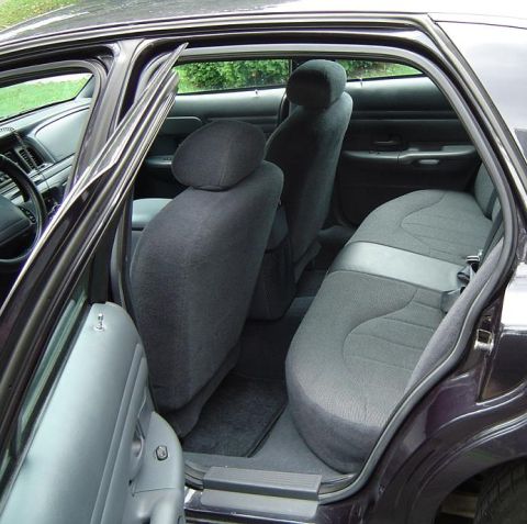 1999 Ford Crown Victoria - View of the rear interior of a sedan, showing the back seats and door panel.