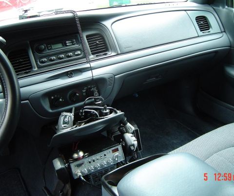 1999 Ford Crown Victoria - The interior of a 1999 Ford Crown Victoria features a CB radio and scanner mounted below the dashboard.