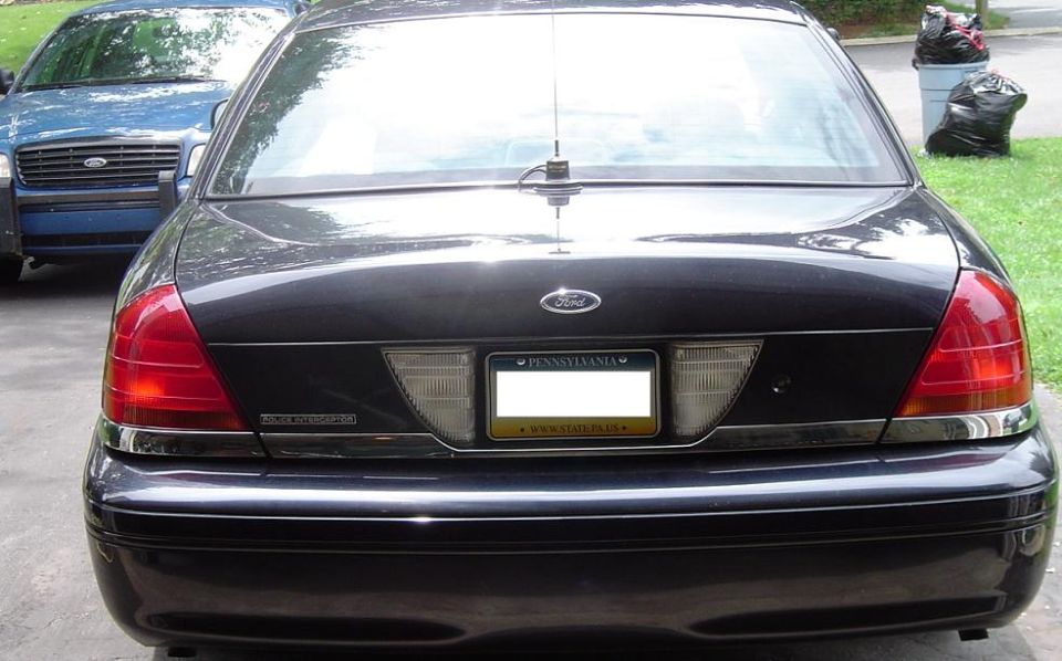 Rear view of a dark sedan parked next to a blue sedan. License plate is from Pennsylvania