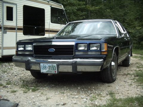 1990 Ford Crown Victoria LTD - This Ford sedan features a prominent grille and chrome bumper, with a license plate reading 188-7193.