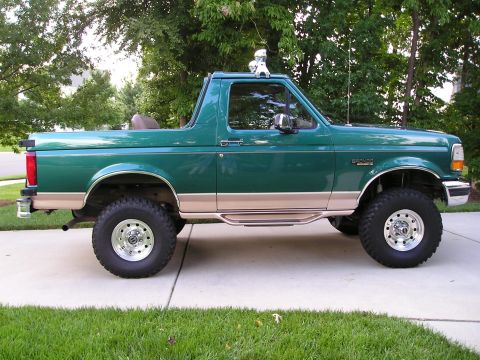 1996 Ford Bronco - This lifted 1996 Ford Bronco is shown from the side, a two-tone green and tan paint scheme.