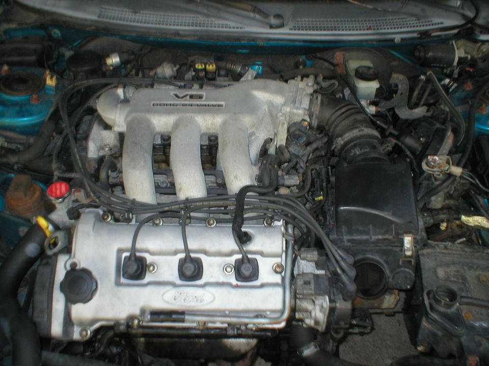 Engine bay of teal car with V6 DOHC 24-Valve intake manifold and Ford valve cover