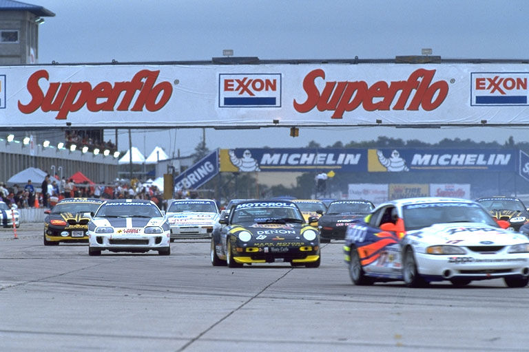 Race cars on a track, including a 1995 Ford Mustang with racing decals