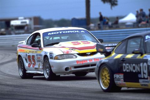 1995 Ford Mustang - A 1995 Ford Mustang race car, number 55, competes on the track with Motorola sponsorship visible.
