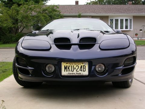 2000 Pontiac Trans Am - A dark blue 2000 Pontiac Trans Am is shown from the front, its distinctive grille and headlights.