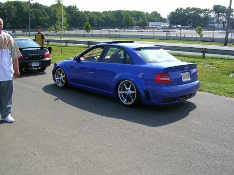 1990 Jeep YJ - Blue Audi sedan with custom wheels and a black Subaru parked on asphalt.