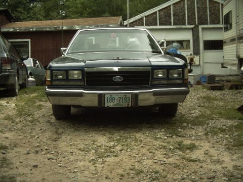 1990 Ford Crown Victoria LTD - Front view of a 1990 Ford Crown Victoria LTD parked outdoors with other vehicles nearby.