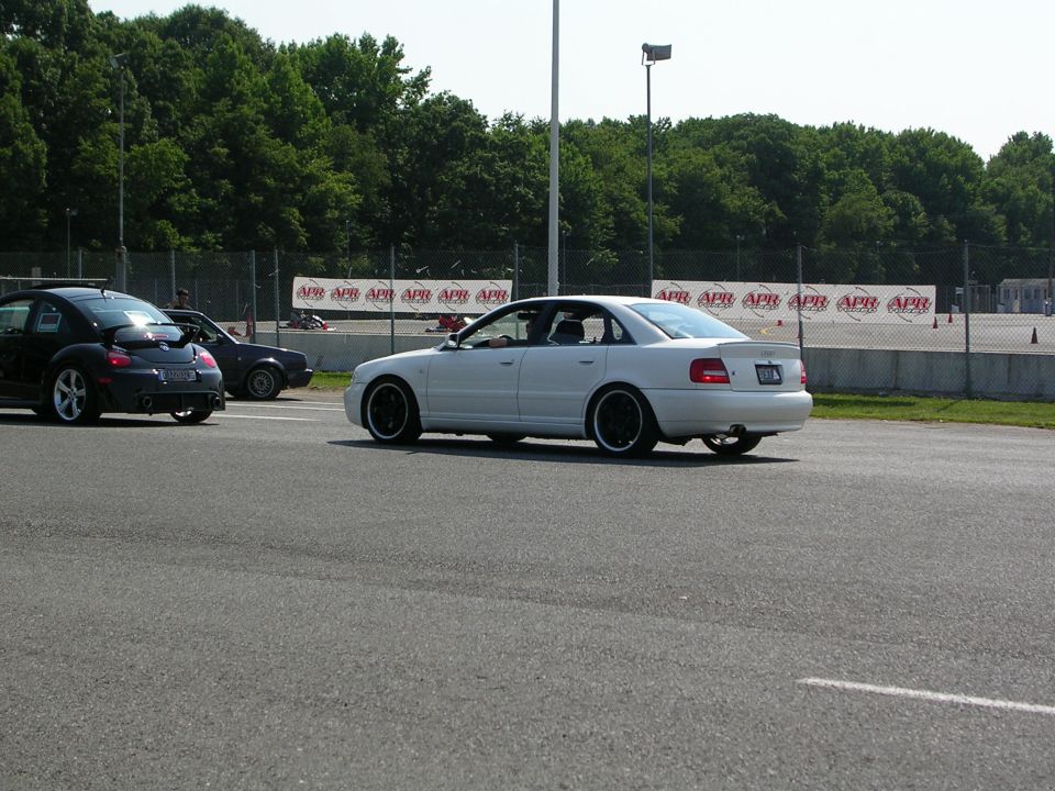 White sedan with black wheels on a race track, side view