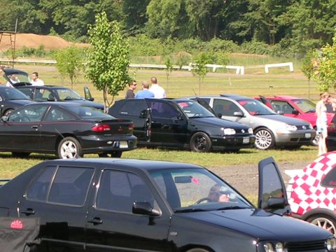1990 Jeep YJ - Several cars are parked on a grassy field during an outdoor event.