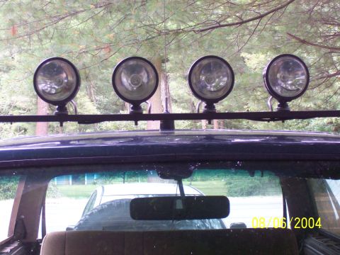 1994 Ford Bronco - A light bar with four spotlights is mounted on the roof of a dark blue SUV.