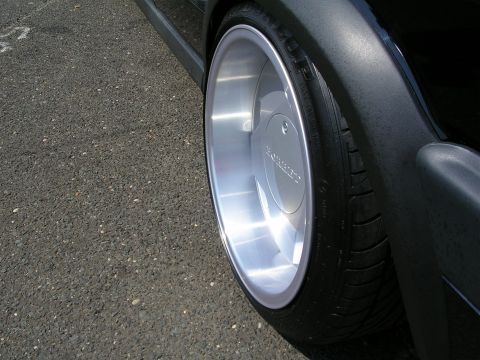1990 Jeep YJ - A close-up view of a shiny aftermarket wheel with 'ROH' branding on the hub, mounted on a dark vehicle.