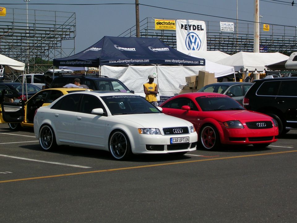 White Audi sedan and red Audi TT parked at an event