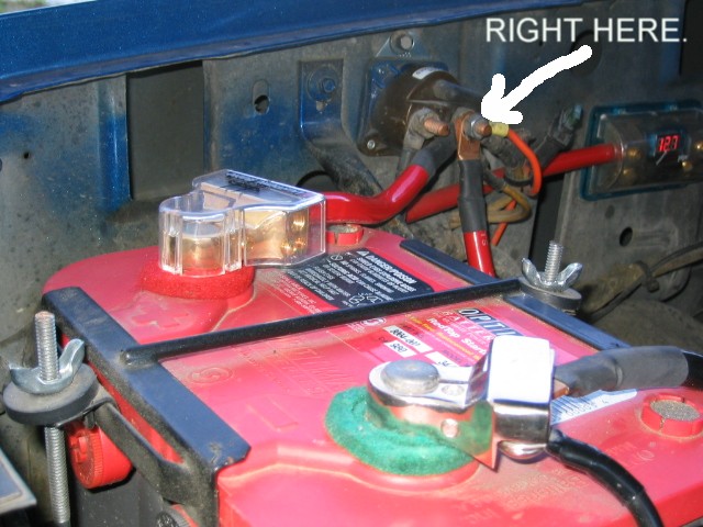 Red Optima battery and fender starter solenoid with arrow labeled RIGHT HERE