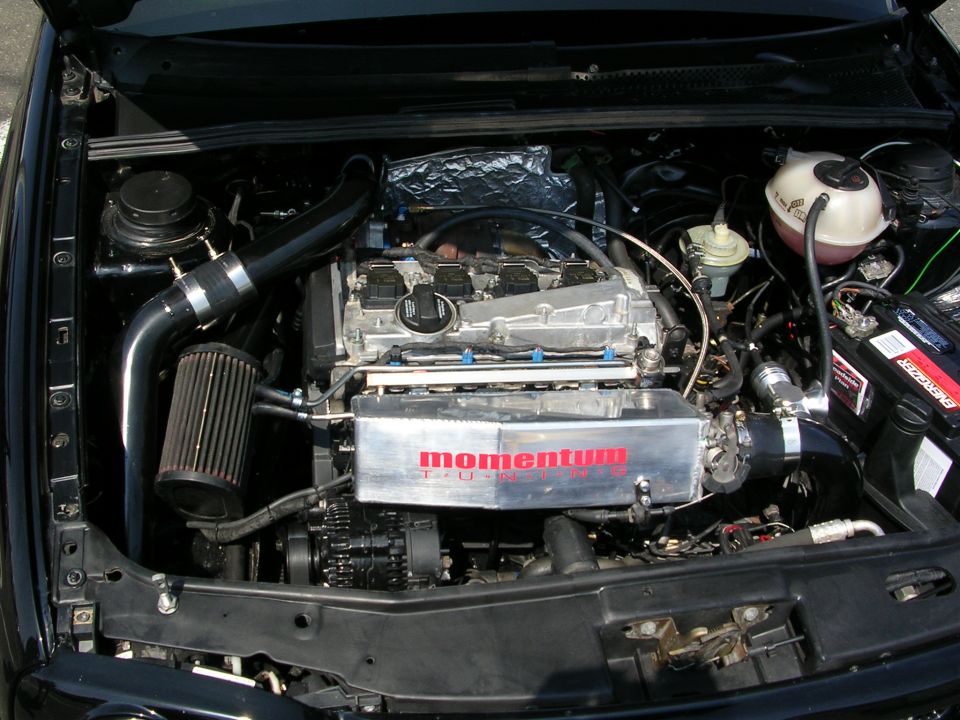 Engine bay with aftermarket intake and "momentum" branded cover
