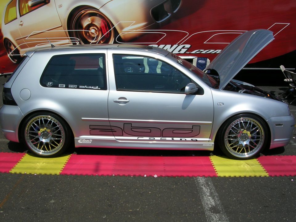 Silver Volkswagen Golf GTI with custom wheels and side graphics, hood open