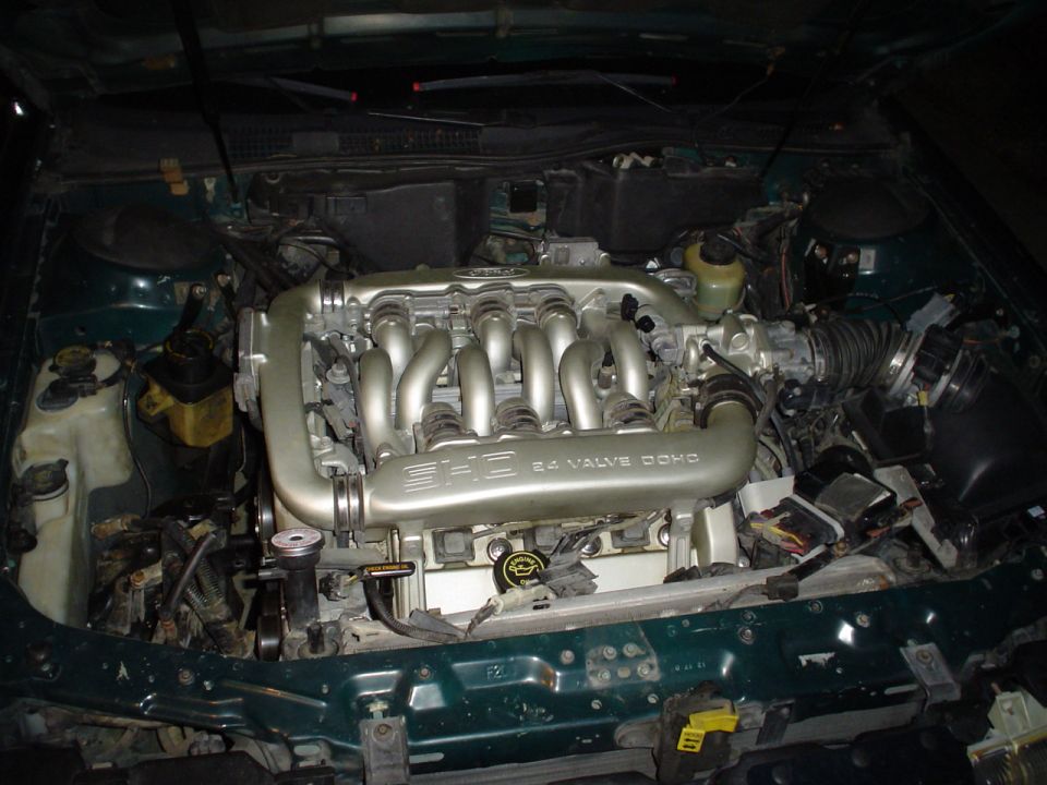 Front-on view of a SHO 24 Valve DOHC engine installed in a green car's engine compartment
