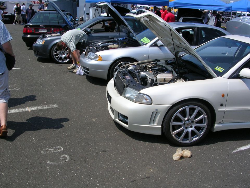 White car with hood open, front 3/4 view, custom wheels