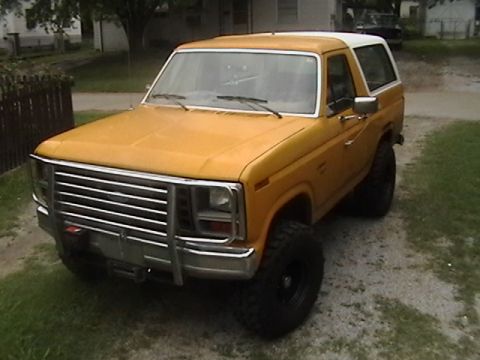 1986 Ford Bronco - This 1986 Ford Bronco features a prominent chrome grille guard and a two-tone yellow and white paint scheme.