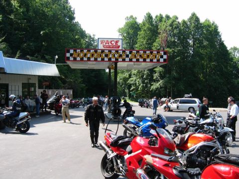 1985 Ford LTD Crown Victoria - A gathering of motorcycles and people at a resort, with a prominent sign indicating the location.