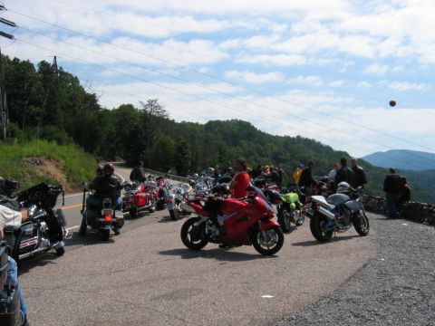1985 Ford LTD Crown Victoria - A gathering of motorcycles on a scenic mountain overlook, with riders socializing.