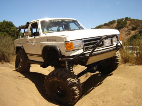 1991 Ford Bronco - This modified 1991 Ford Bronco navigates a dirt trail with its impressive suspension and oversized tires.