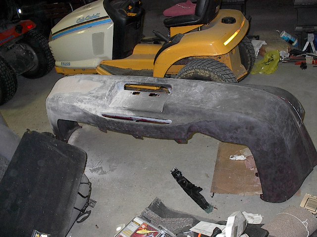 Unpainted car bumper with license plate area and cutouts for lights