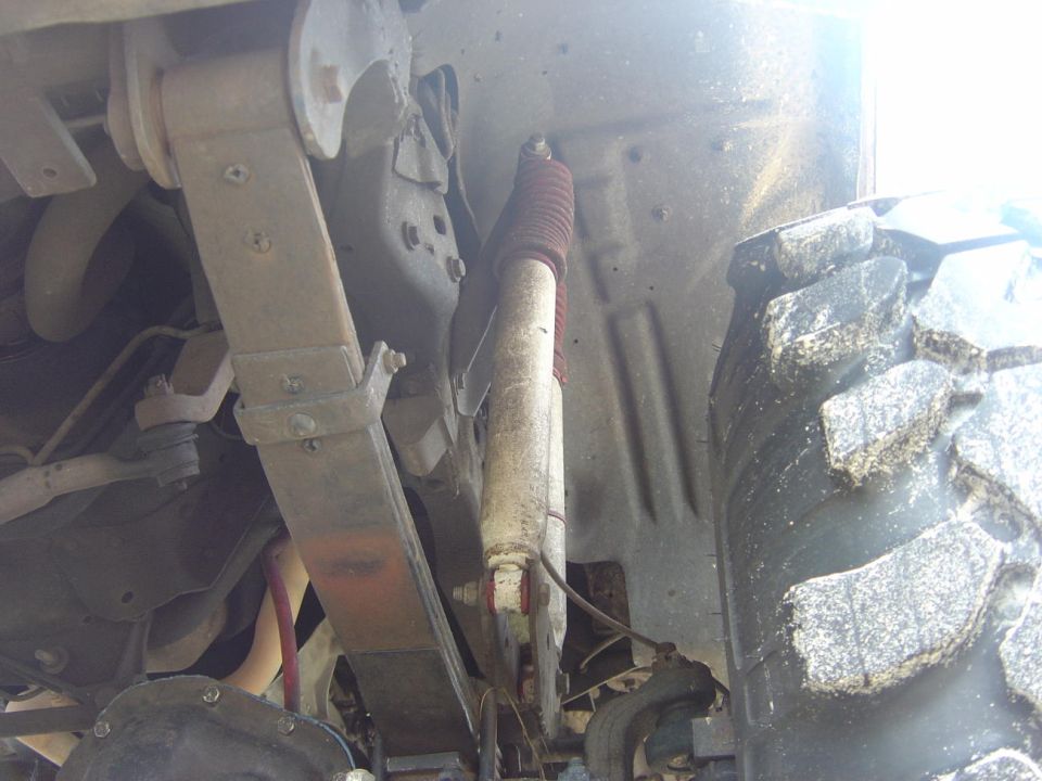 Underside suspension of Bronco showing shock, coil spring, and off-road tire
