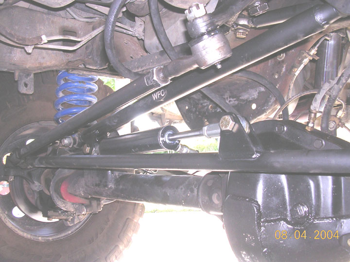 Front axle underside with blue coil, hydraulic steering damper, and WFO-stamped track bar