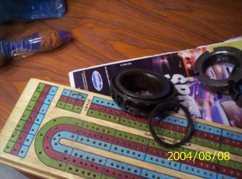 1986 Ford Bronco - Car parts and a cribbage board are laid out on a wooden surface.