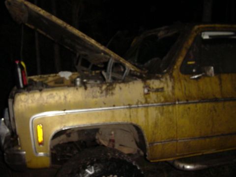1989 Ford Bronco - This weathered yellow pickup truck has its hood open, revealing the engine bay.