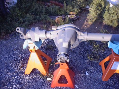 1988 Ford Bronco - A vehicle axle assembly is supported by jack stands, appearing to be recently cleaned and painted.