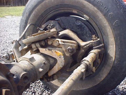 1988 Ford Bronco - Close-up view of a vehicle's front axle and braking system, with visible signs of age and use.