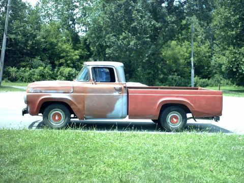 1954 Ford F-100 - This 1958 Ford F-100 pickup truck shows significant rust and primer patches along its body panels.