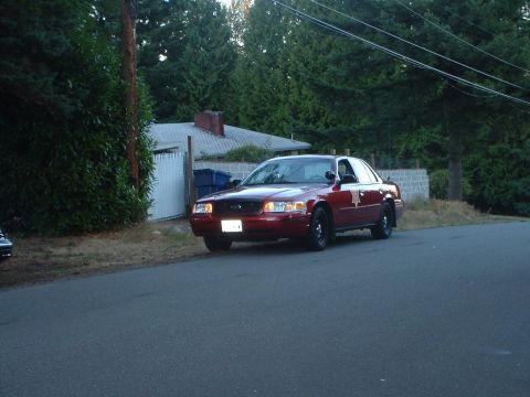 1999 Ford Crown Victoria - This 1998 Ford Crown Victoria sedan, possibly a police or security vehicle, is seen parked curbside on a tree-lined street.