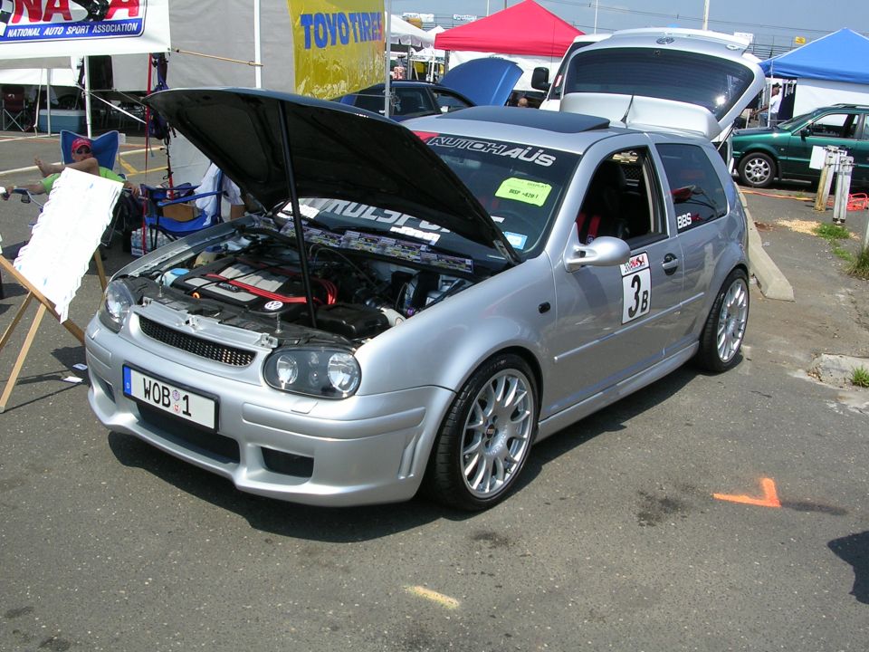 Silver Volkswagen Golf GTI with hood open, showing engine. BBS wheels and racing numbers visible