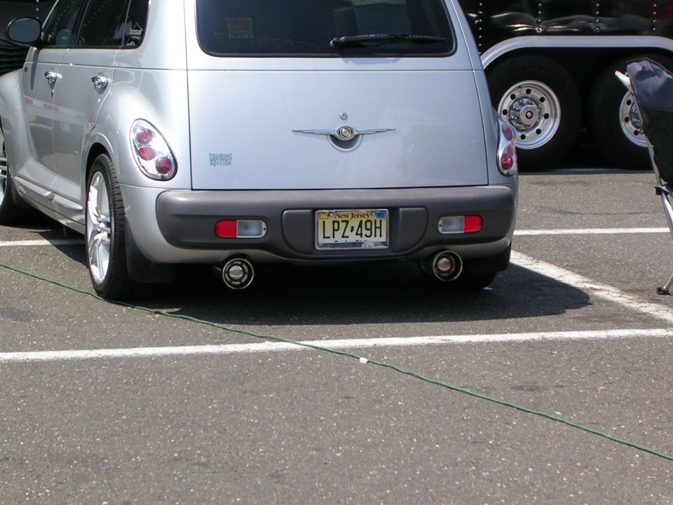 Rear of a silver Chrysler PT Cruiser with dual exhaust and a New Jersey plate at a show