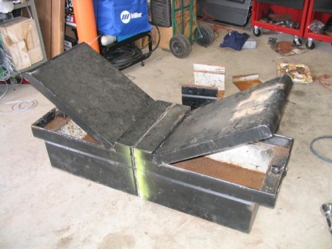1986 Ford F-150 - A black metal toolbox with its lids open, sitting on a concrete floor in a garage setting.