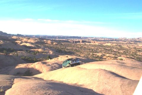 1996 Ford Bronco - A green SUV navigates a rocky desert landscape under a clear blue sky.