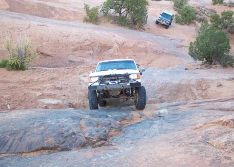 1996 Ford Bronco - Two off-road vehicles navigate a challenging rocky landscape with sparse vegetation.