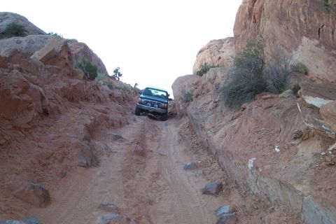 1996 Ford Bronco - A truck navigates a challenging off-road path through a canyon.
