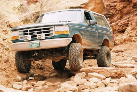 1996 Ford Bronco - Off-road adventure in a 1996 Ford Bronco navigating a challenging rocky path.