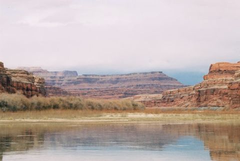 1996 Ford Bronco - A wide river reflects the sky and layered rock formations in a desert canyon.