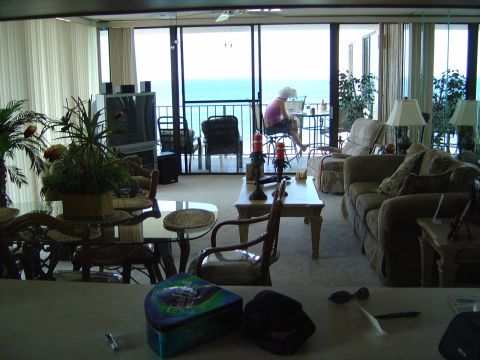 1986 Ford Bronco - A person works on a laptop on a balcony overlooking the ocean, with a living room in the foreground.