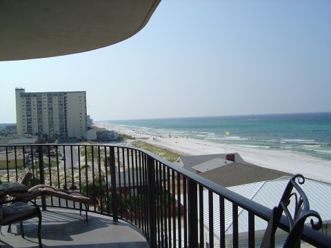 1986 Ford Bronco - A view from a balcony shows a beach, ocean, and buildings under a clear blue sky.
