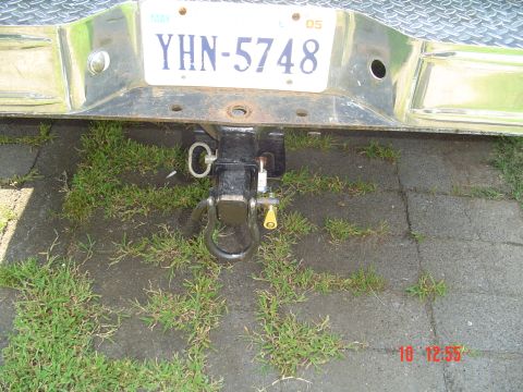 1989 Ford Bronco - Close-up of a vehicle's rear hitch and license plate, with grass and pavement visible.